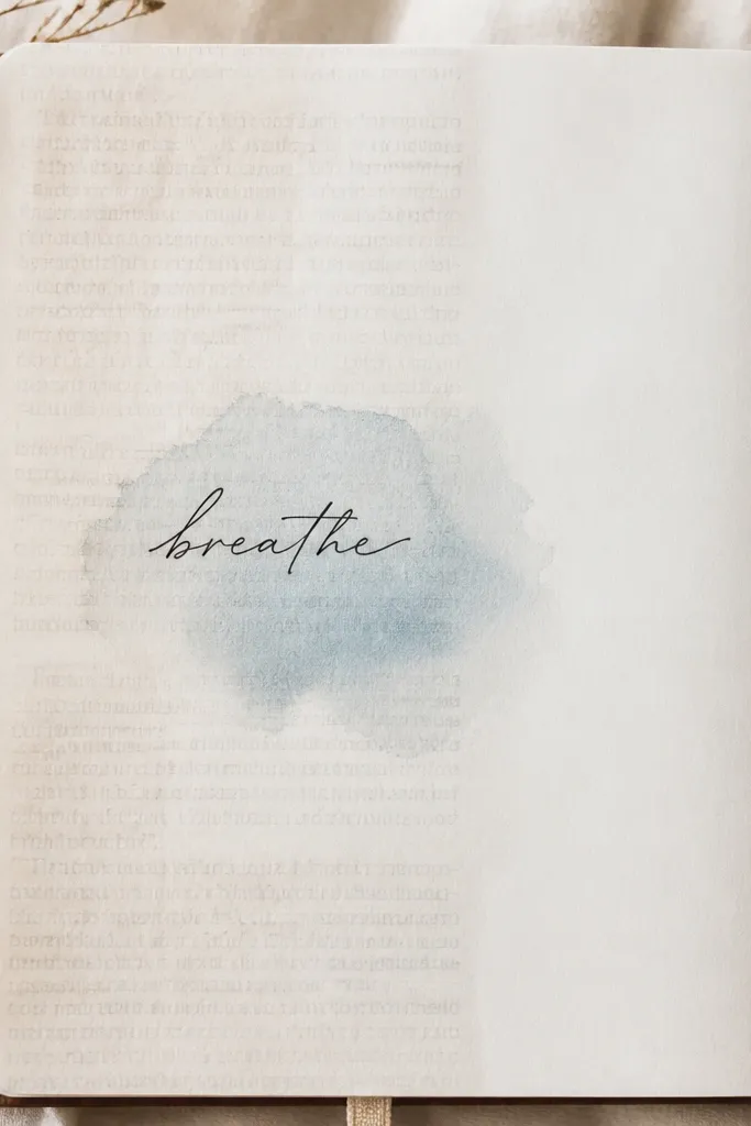 A diary page where the left half is covered with faded book text in light gray. On top, a single handwritten title sits in the center, and a small watercolor wash sits behind the title.
