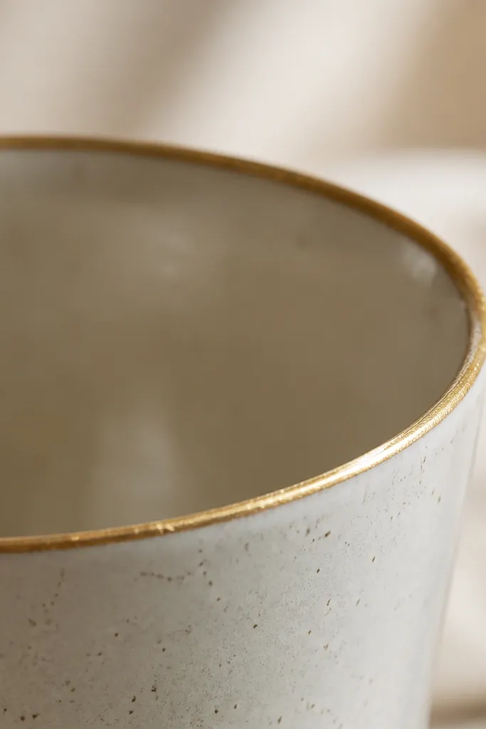 Top rim close-up with a delicate gold line painted around the edge, slightly uneven but neat, catching light like a tiny frame.