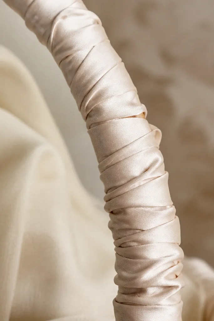 Close-up of a handle wrapped in ribbon with visible wrinkles and bunching; the ribbon overlaps unevenly.