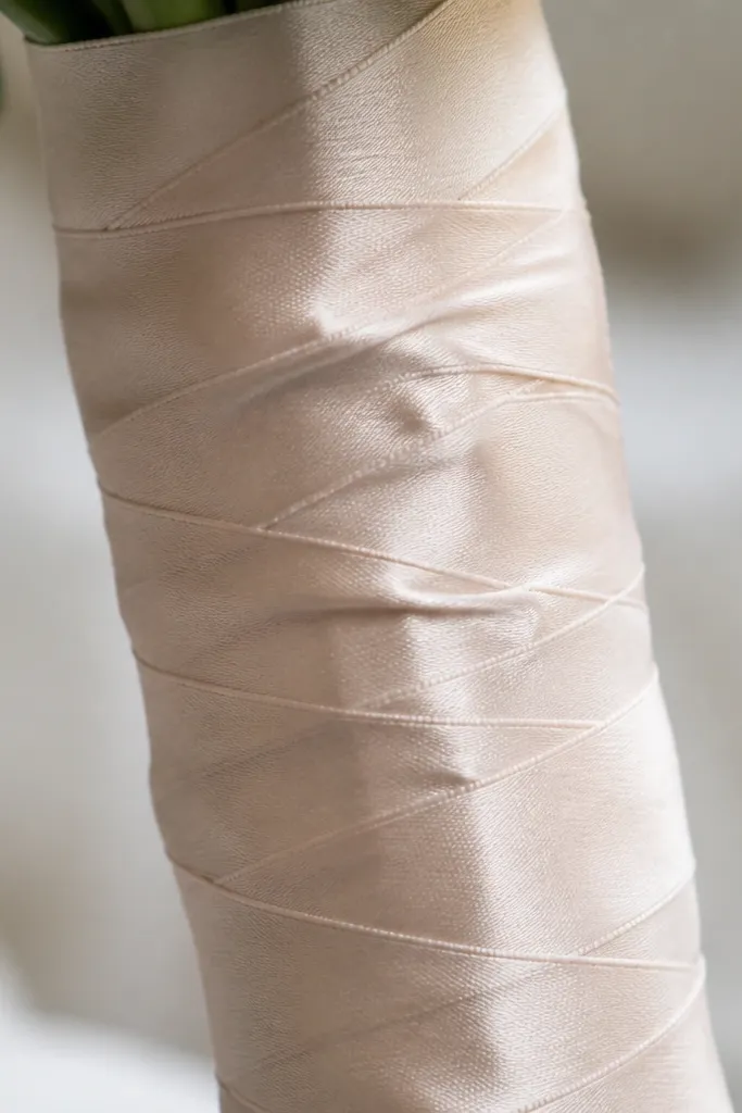 Close-up of a stem where thick tape overlaps and creates raised lumps under a decorative wrap.