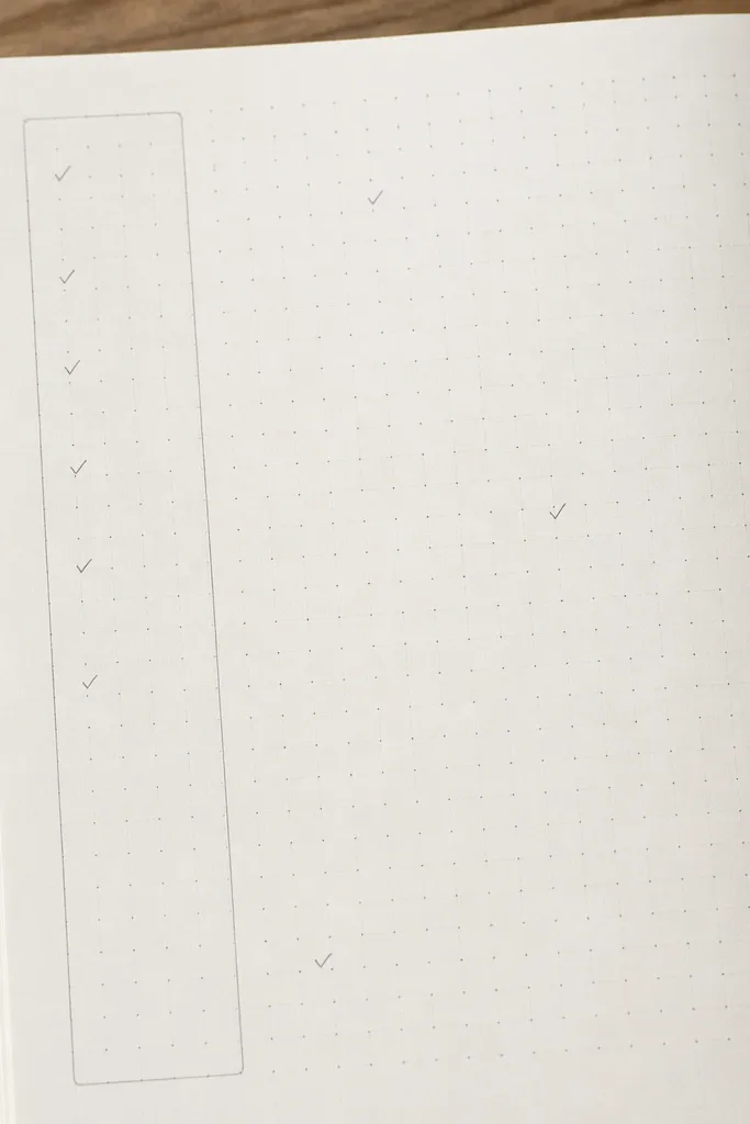 A page with a dotted grid drawn lightly in pencil, a small to-do box on the left, and a larger writing area on the right. Small checkmarks and one tiny icon decorate the grid intersections.